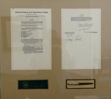 Ceremonial pen and papers in a frame.